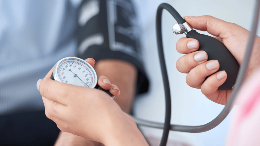Primer plano de las manos de una doctora midiéndole la presión arterial a un paciente